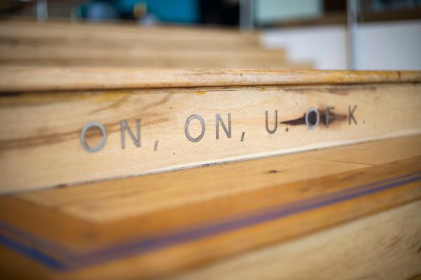 A wooden staircase is engraved with the phrase "on, on, U of K."