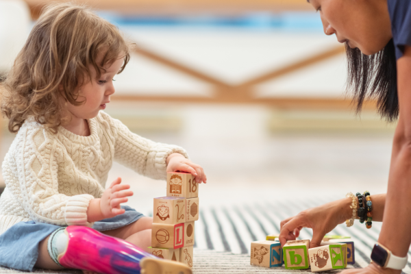 girl and female playing with blocks on the floor