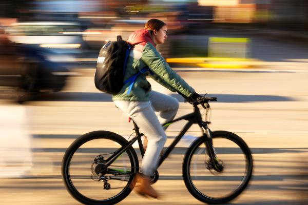 Student riding a bicycle through campus