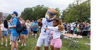 Wildcat and a student taking a photo at an event