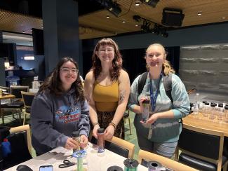 Three people gathered around a table holding their sensory jar creations.
