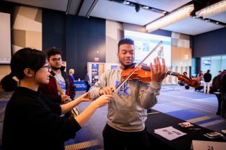 student experiencing violin station