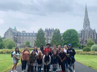 Explore First students pose in front of a castle in Ireland.