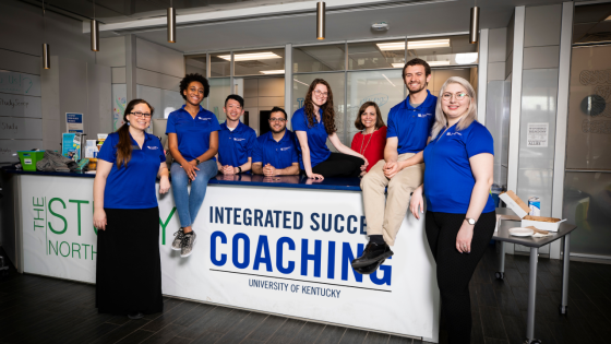 Staff members posing around a sign that says "Integrated Success Coaching"