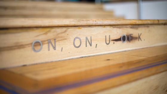 A wooden staircase is engraved with the phrase "on, on, U of K."