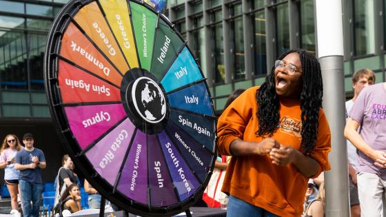 International student spinning a prize wheel
