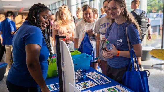 Student engaging with a staff member at an opening event during tabling.