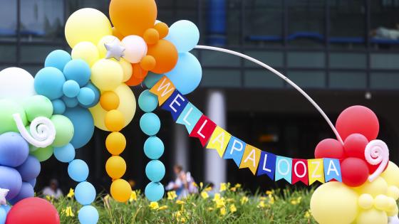 A bright banner that reads Well-A-Palooza surrounded by brightly colored balloons.