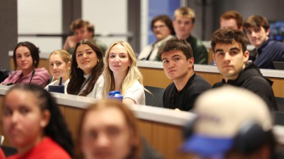 A group of students in a room while watching a presentation.
