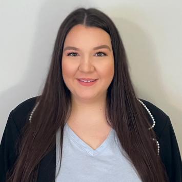 A White woman with long brown hair smiling at the camera