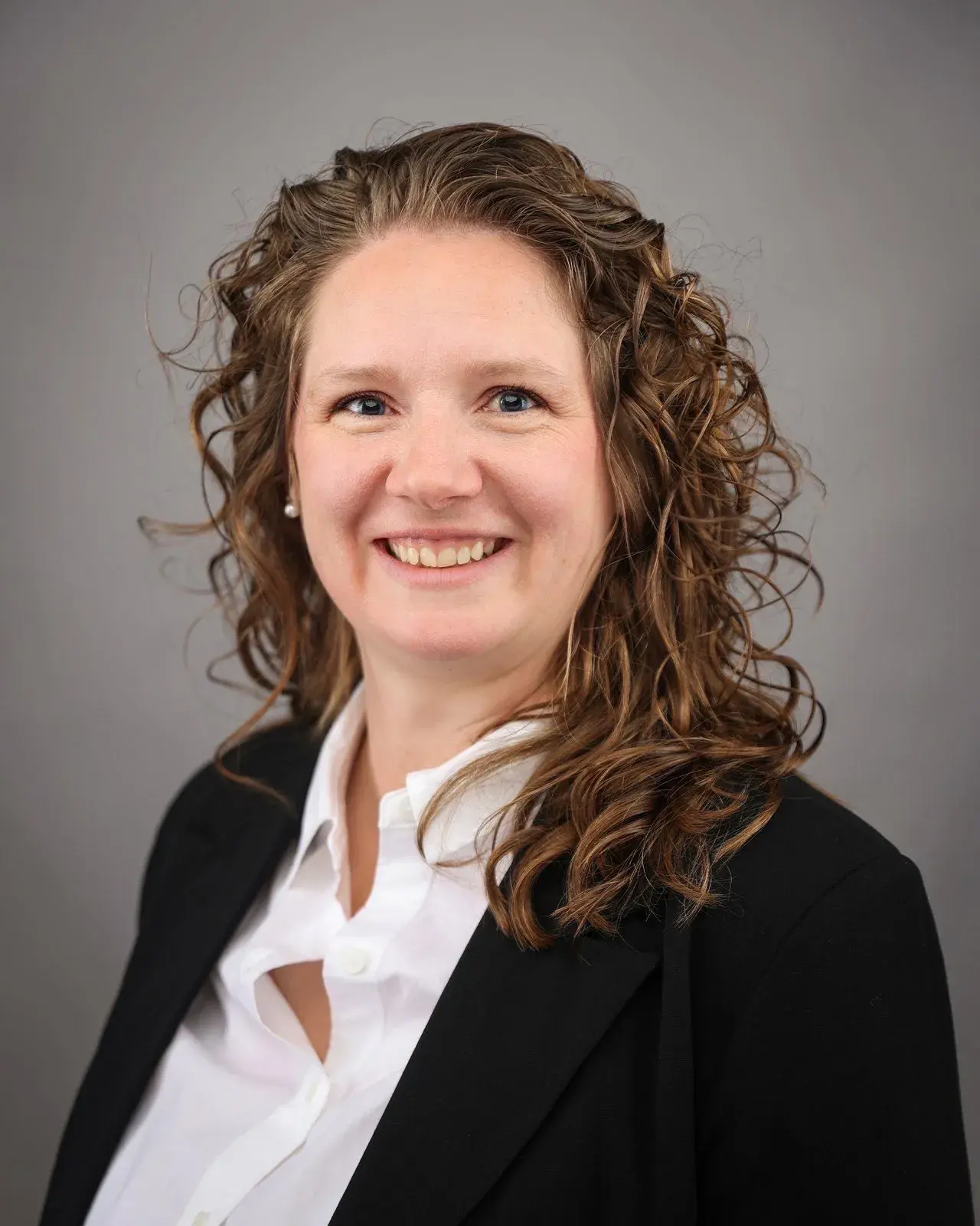 Headshot of a female wearing a black blazer and white button down.