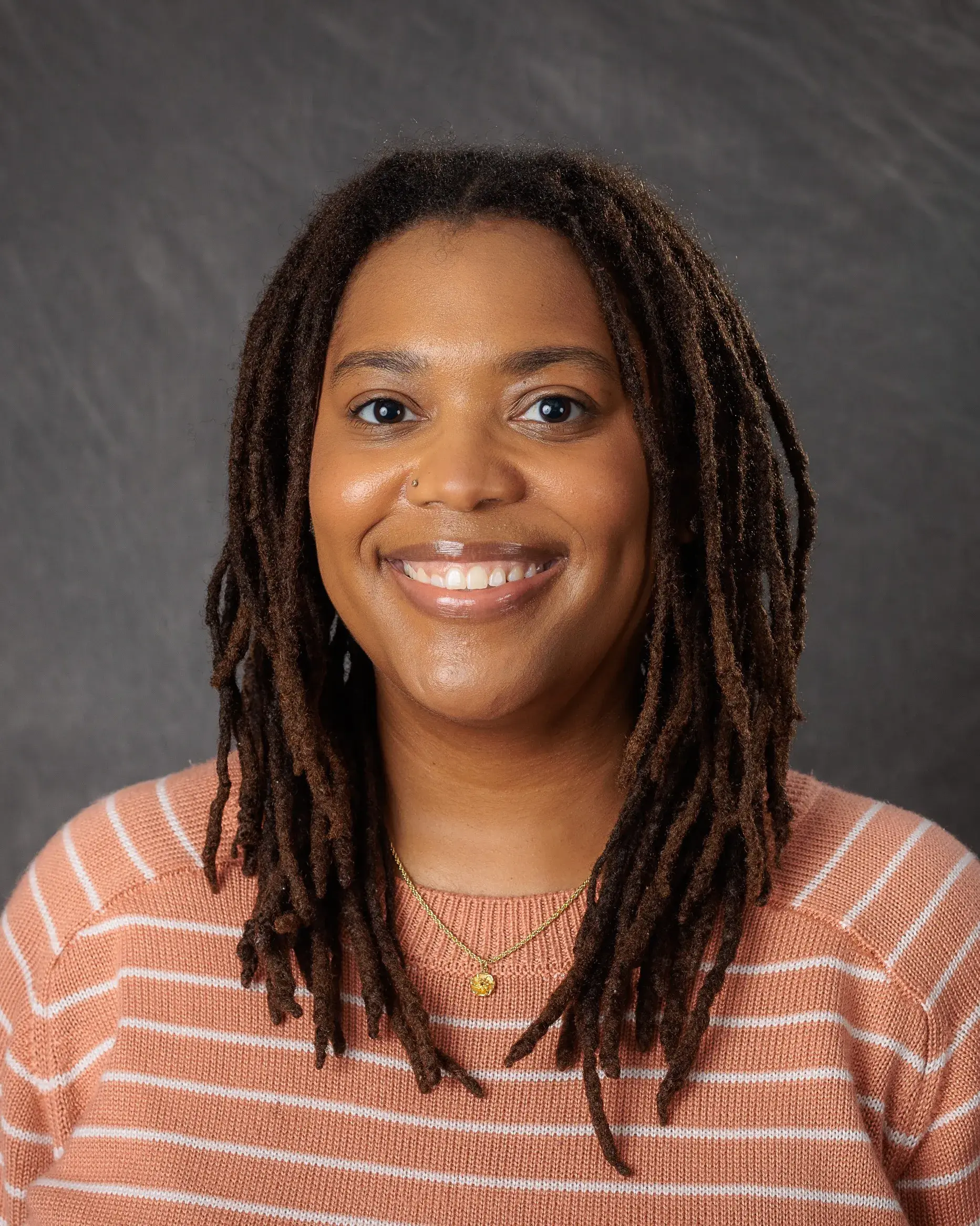 Dr. Natese Dockery, an African American woman with shoulder length hair smiles at the camera