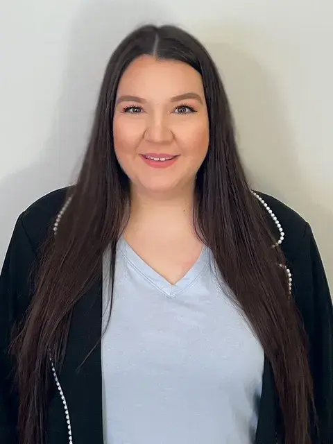A White woman with long brown hair smiling at the camera